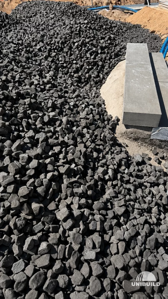 Kruszywo ze szkła spienionego ułożone przy elementach betonowych na budowie